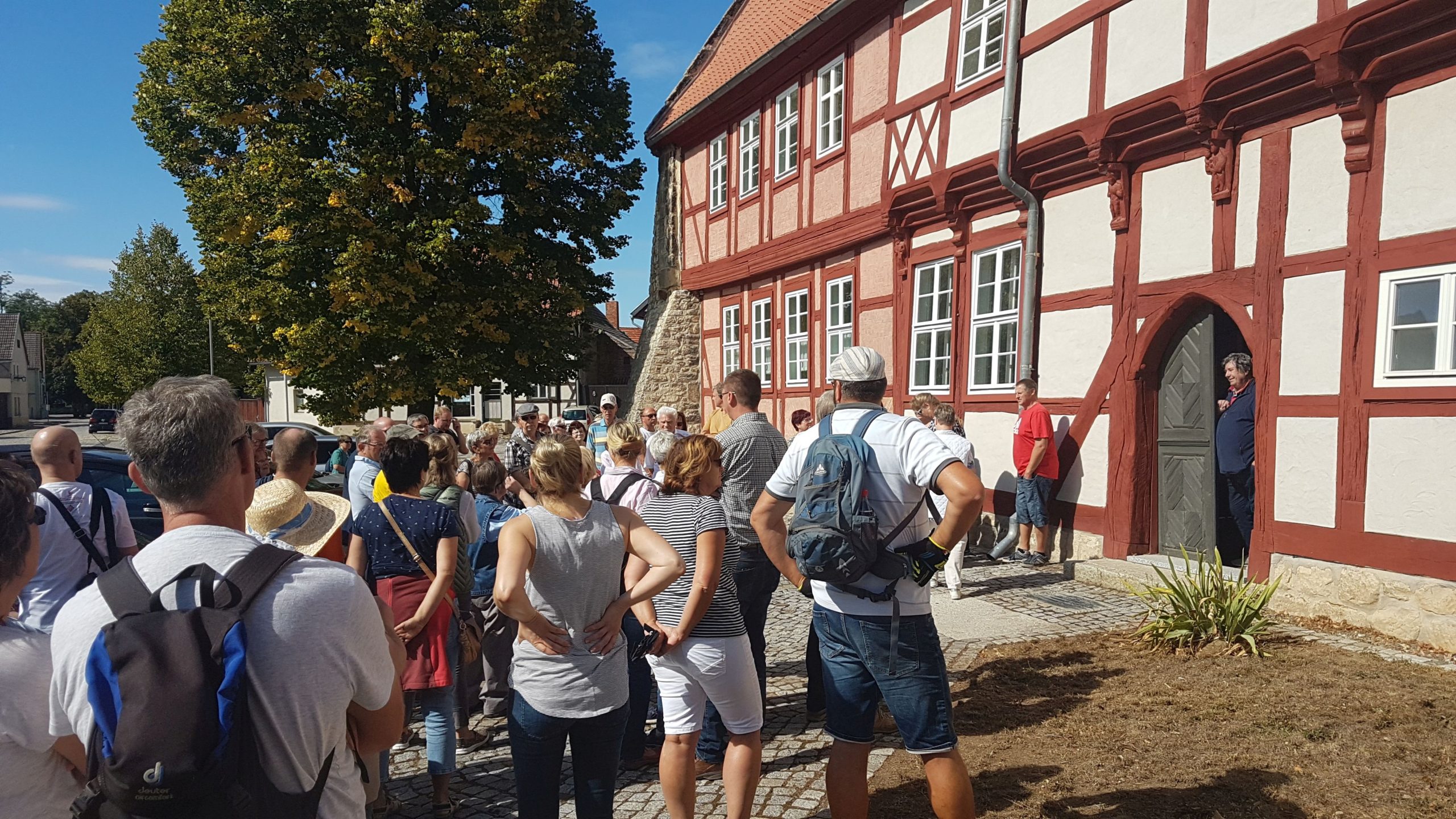 Teilnehmer eines Dorfrundgangs beim Tag des offenen Denkmals in Ditfurt vor dem historischen Rathaus, einem Fachwerkbau von 1534.
