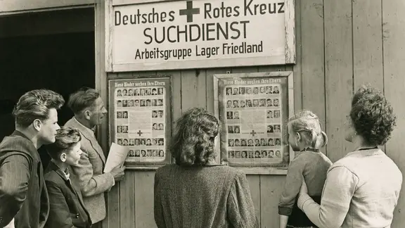 Im Jahr 1949 suchen Eltern im Lager Friedland nach ihren Kindern.